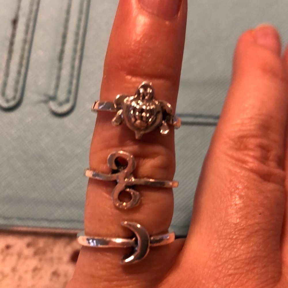 Three pinky rings in silver, moon, turtle and infinity loop